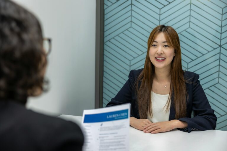 Young woman in a business meeting with an interviewer, showcasing confidence and professionalism.